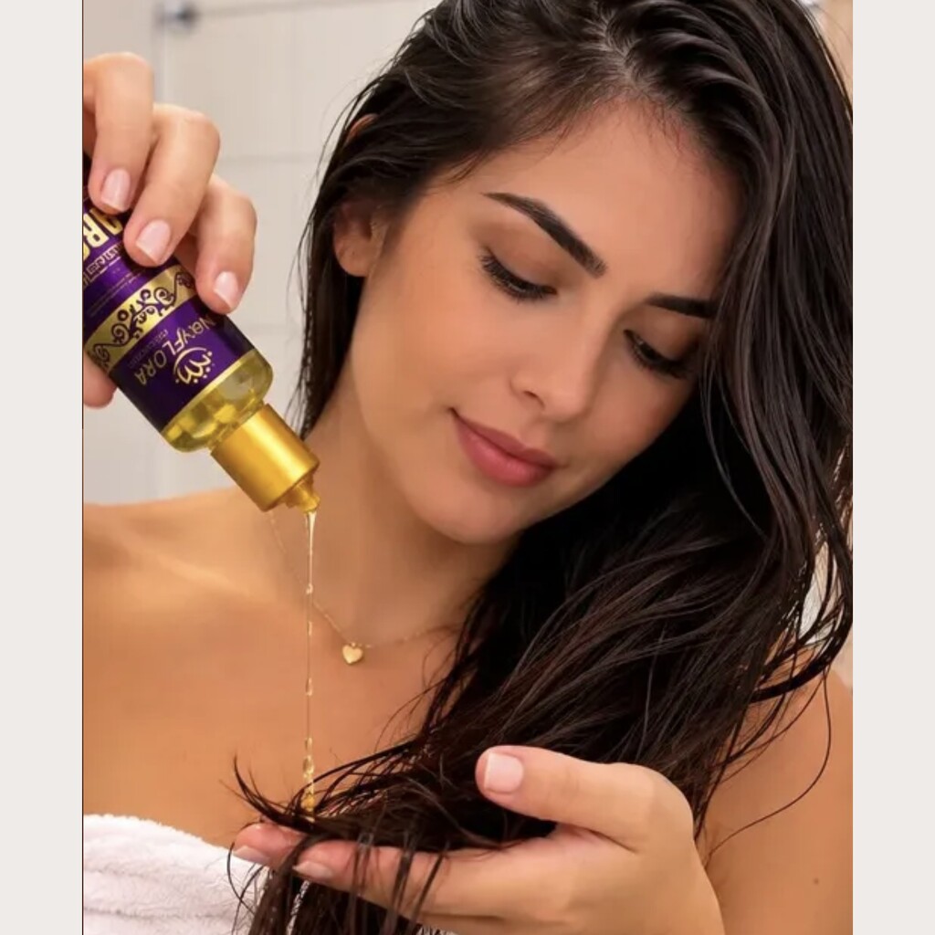 Mulher aplicando o Reparador de Pontas Óleo de Argan no cabelo